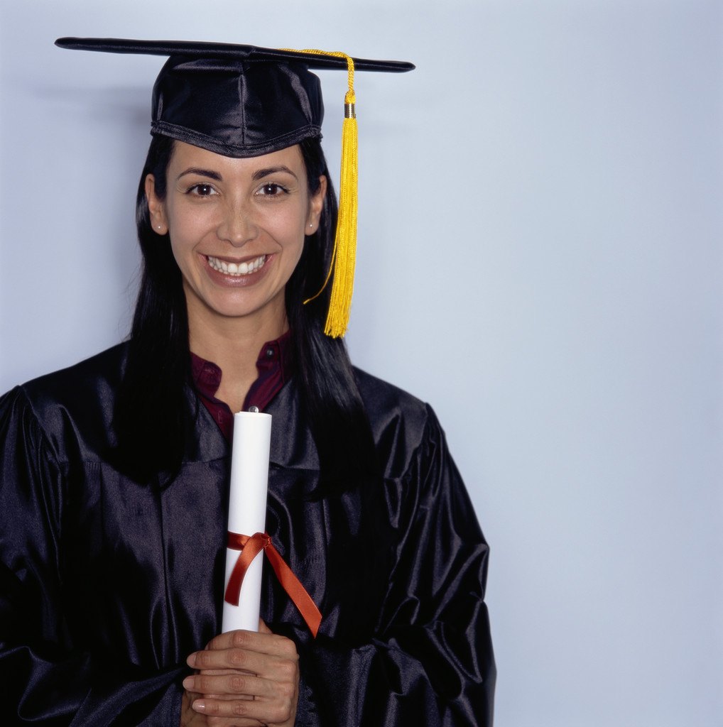 Etudiante en toge de graduation tenant son diplome, illustrant la mention Bien ou Tres Bien au bac
