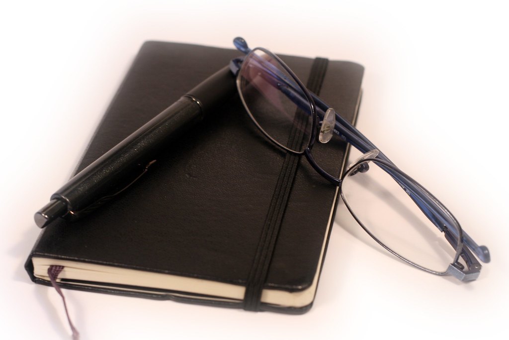 Carnet, lunettes et stylo prêts pour utiliser le simulateur de note du brevet 2026
