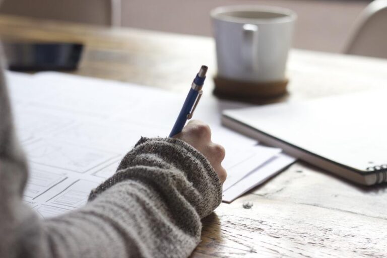 Étudiant notant ses résultats de contrôle continu pour simuler sa note au bac